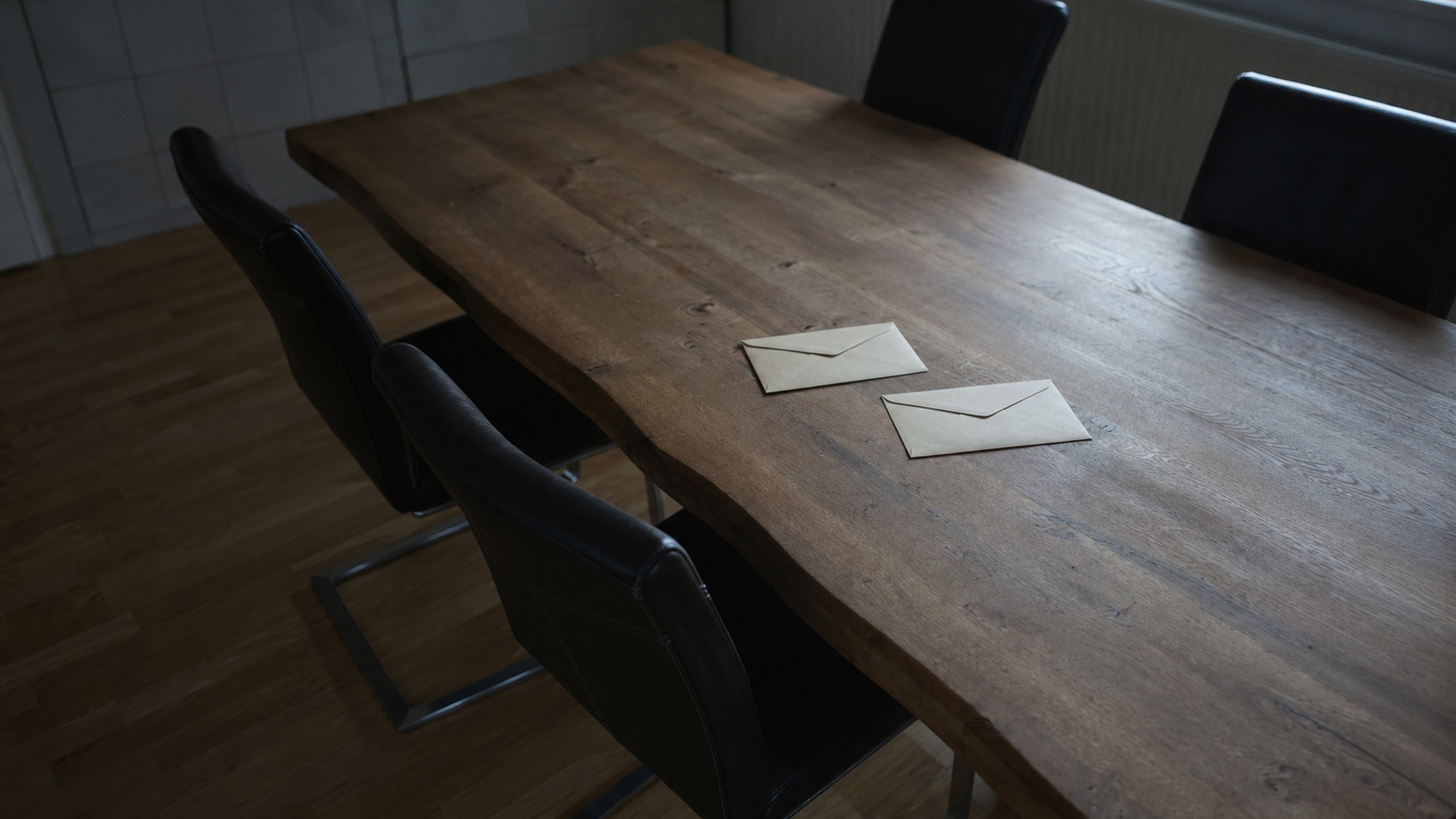 Zwei ungeöffnete Briefe auf einem Holztisch im kühlen Morgenlicht