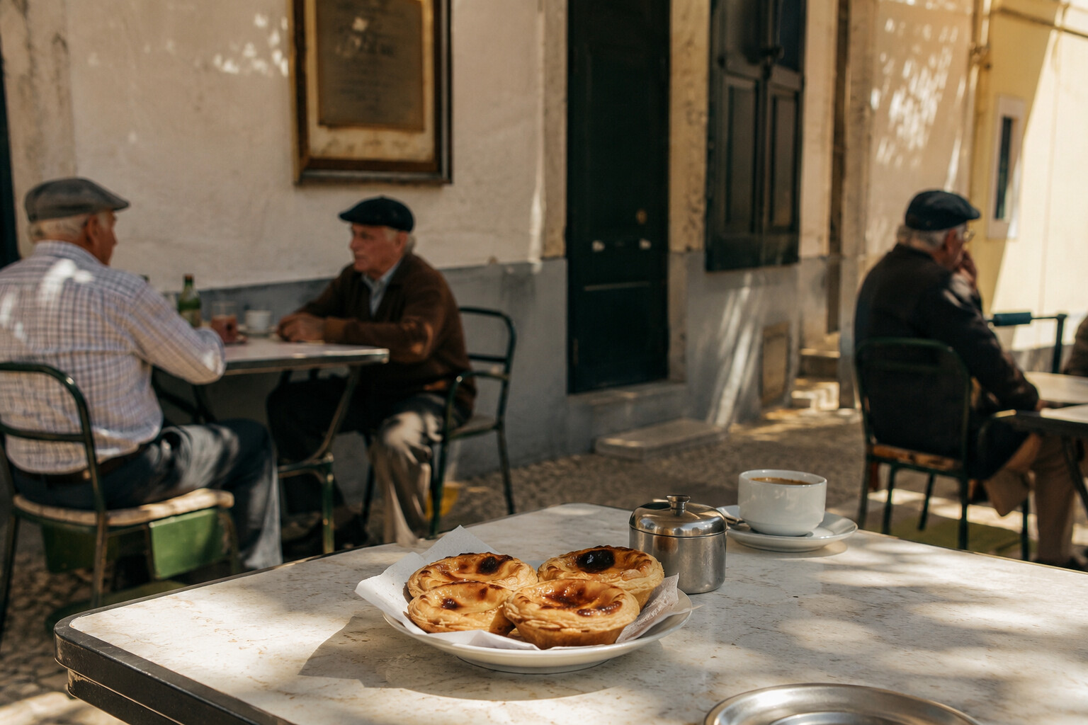 Kleines portugiesisches Straßencafé mit Pastéis de Nata auf dem Tisch