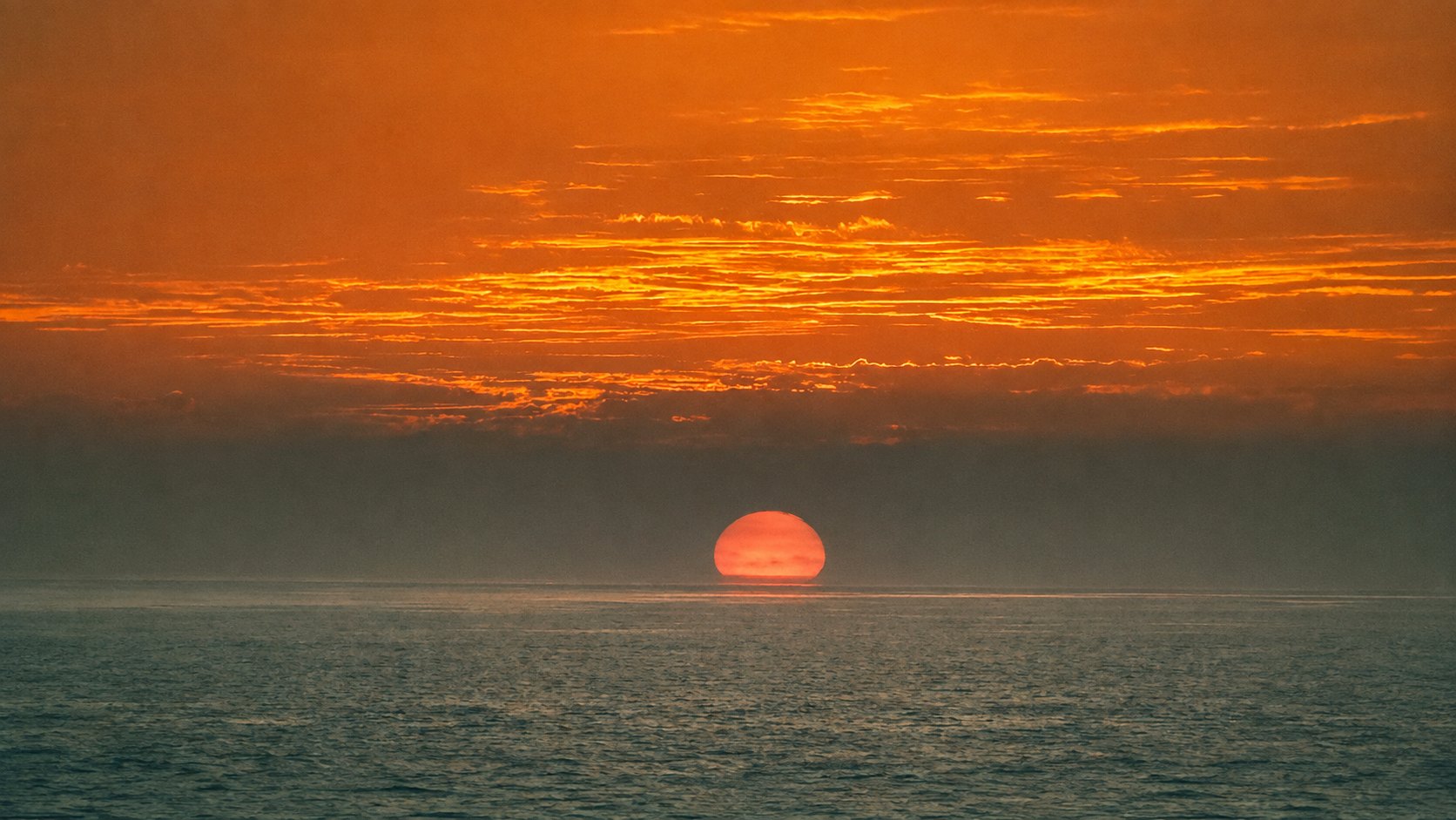 Der Moment, in dem die Sonne ins Meer fällt und verdampft