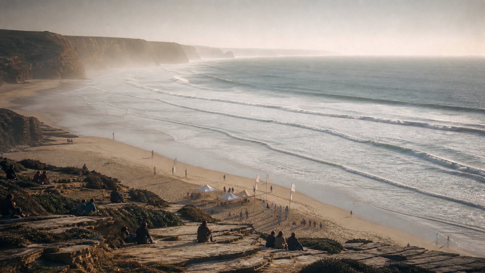 Surfbucht von den Klippen aus, Zelte am Strand und brechende Wellen